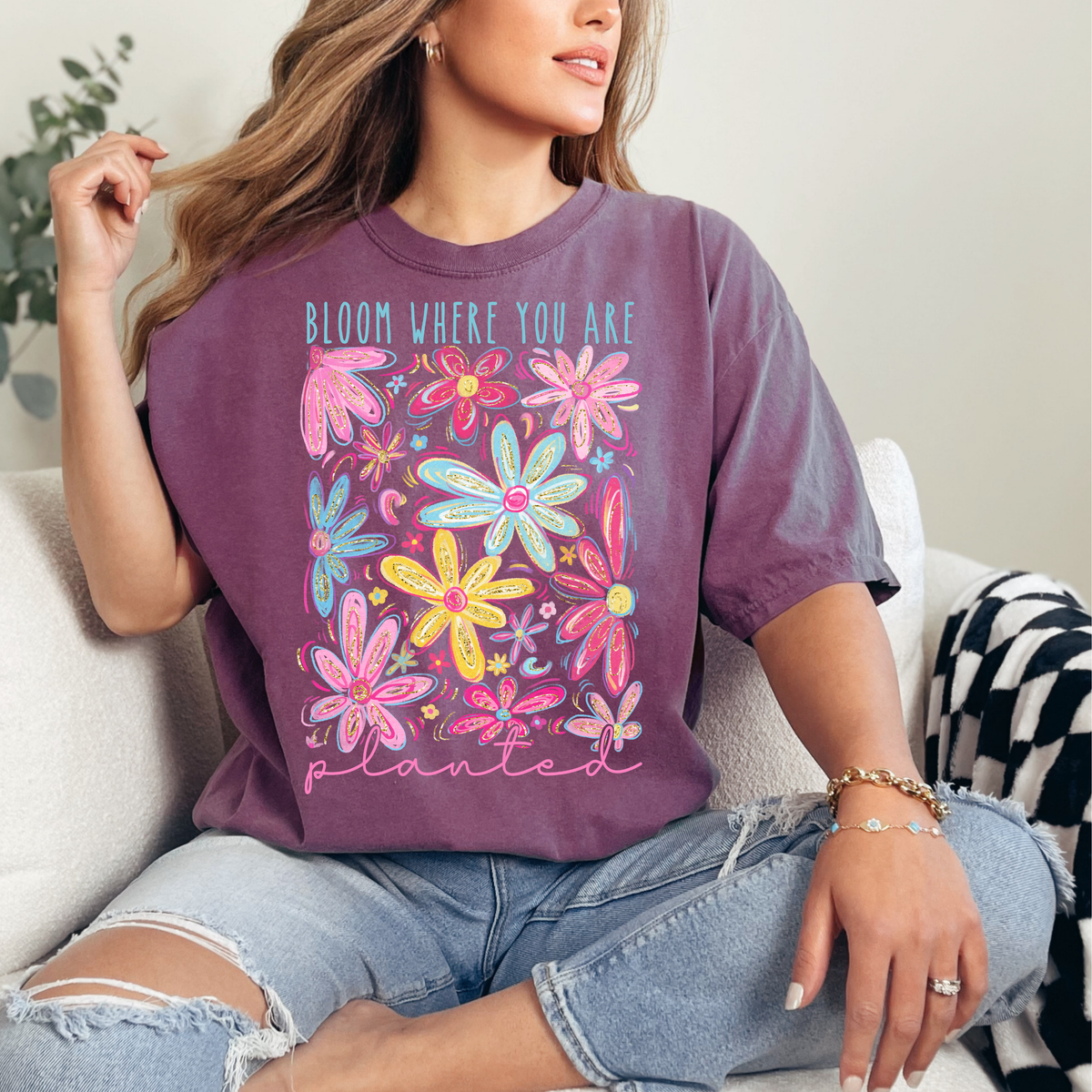 Person wearing a purple t-shirt with colorful floral design and text